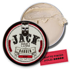 Jack the Barber clay product with open lid showing cream inside on a white background